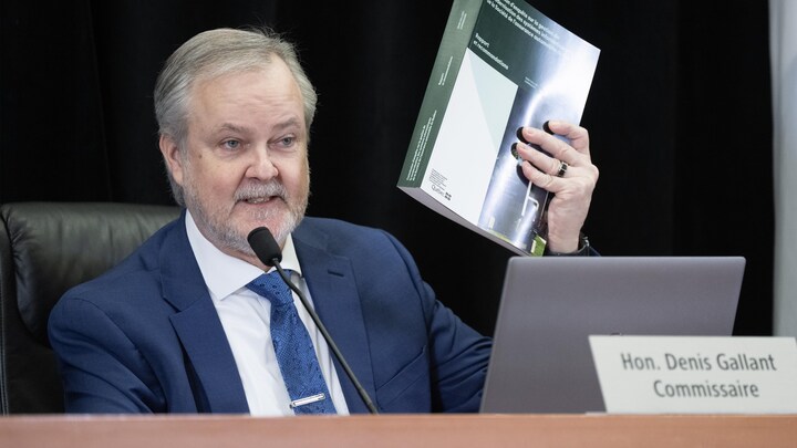 Le commissaire Gallant tient dans ses mains le rapport de près de 600 pages de la commission.