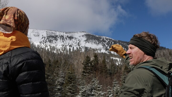 Des organisateurs de l'événement devant une montagne.