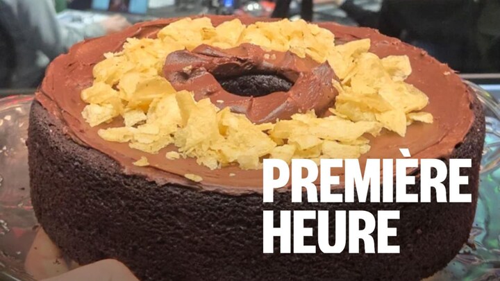 Une personne tient un gâteau devant un studio de radio.