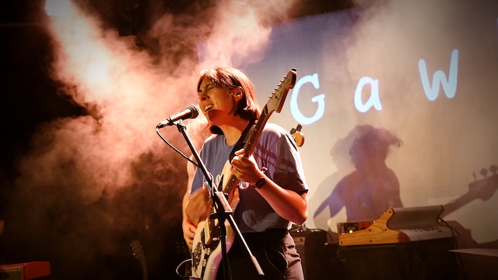 l'artiste sur scène à la guitare
