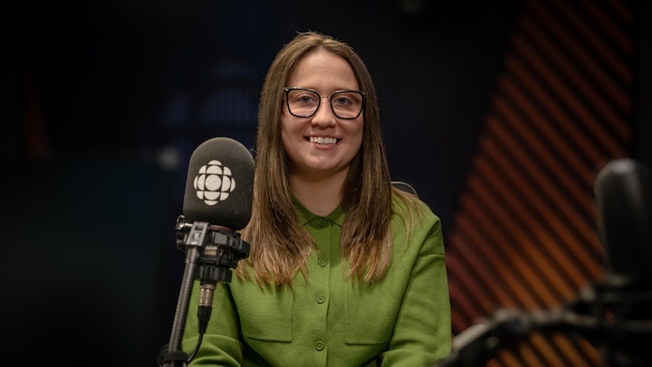 Lilia sourit devant un micro dans le studio.