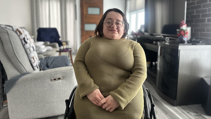 Une femme de petite taille dans un fauteuil roulant.
