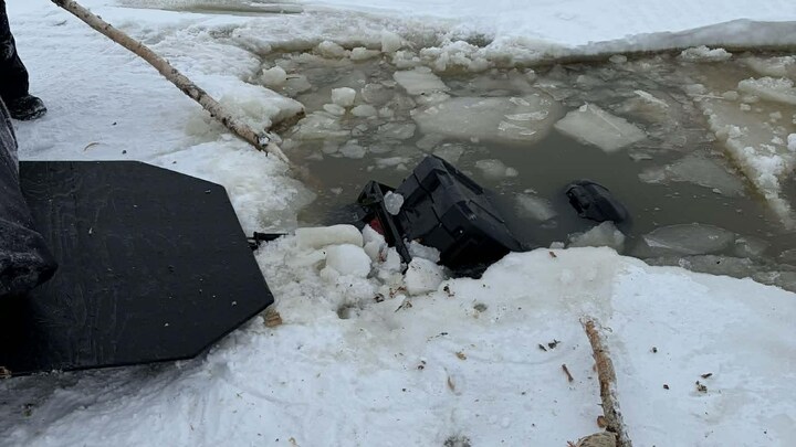 Une motoneige sombre dans l'eau, sous la glace du lac Abitibi.
