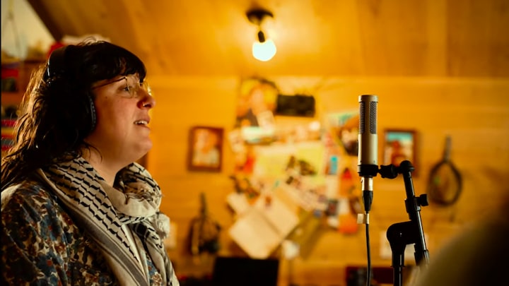 L'auteure-compositrice-interprète, Sylvie Boulianne, chante au micro dans un décor intérieur chaleureux.
