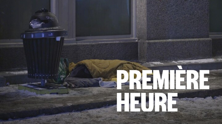 Une personne dort dans un sac de couchage sur un trottoir de Québec à côté d'une poubelle. De la neige recouvre partiellement le sol.