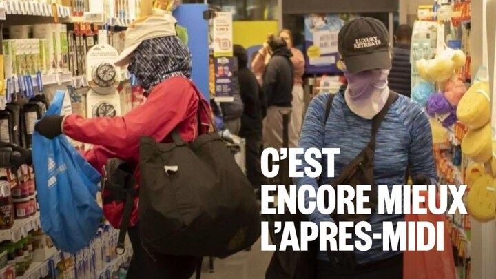 Des personnes dont le visage est caché mettent des items dans des sacs dans une allée d'épicerie.