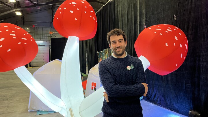 Rodrigue Turgeon pose dans la zone jeunesse du Salon du livre de l'Abitibi-Témiscamingue, souriant.