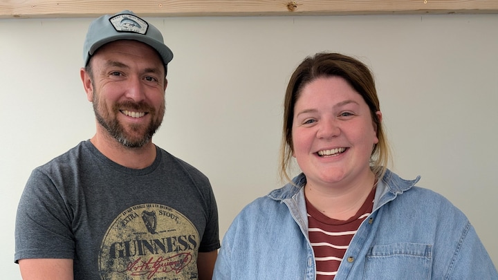 Matt Brophy et Lyndsey Liston sont debout près d'une table, sur laquelle on voit des bocaux remplis de semences.
