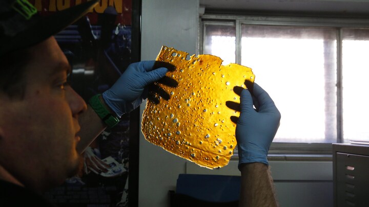 Dans cette photographie prise à Denver, au Colorado, un homme tient un concentré de THC, connu sous le nom de « shatter ».