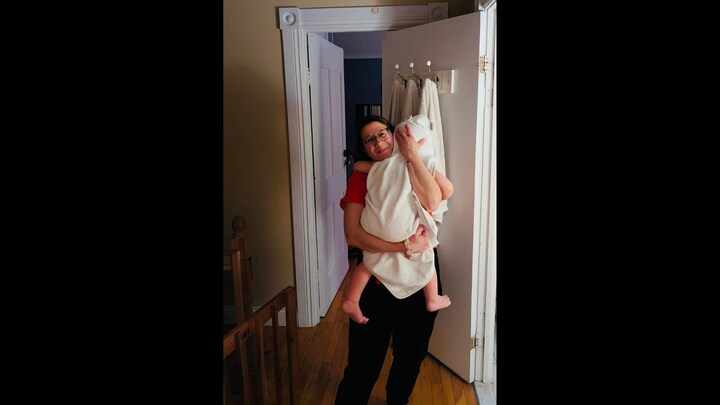 Sophie Gemme tient dans ses bras un enfant enroulé dans une serviette.