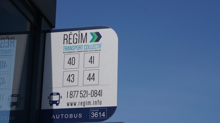 Une pancarte de la Régie intermunicipale de transport. Gaspésie – Îles-de-la-Madeleine indique quelles lignes d'autobus passent à un arrêt donné.