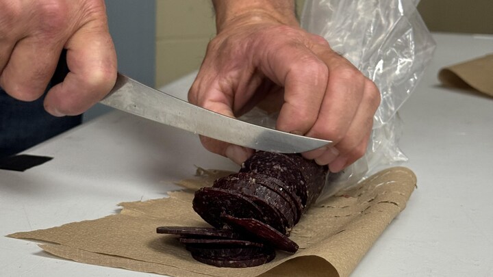 Un coupe des tranches de saucisson de loup marin. 