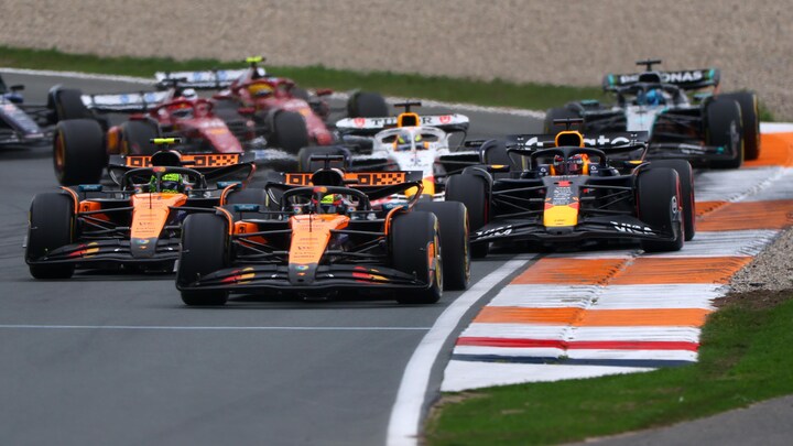 Oscar Piastri, au volant de sa McLaren, négocie un virage devant son équipier Lando Norris et le pilote Red Bull Max Verstappen. 