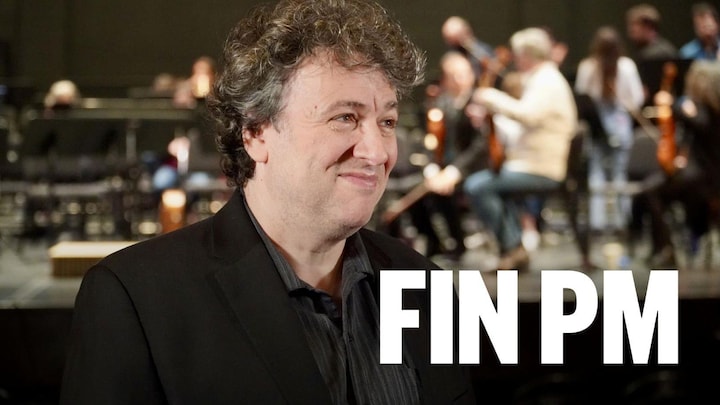 Alain Trudel dans une salle de spectacles devant des musiciens.