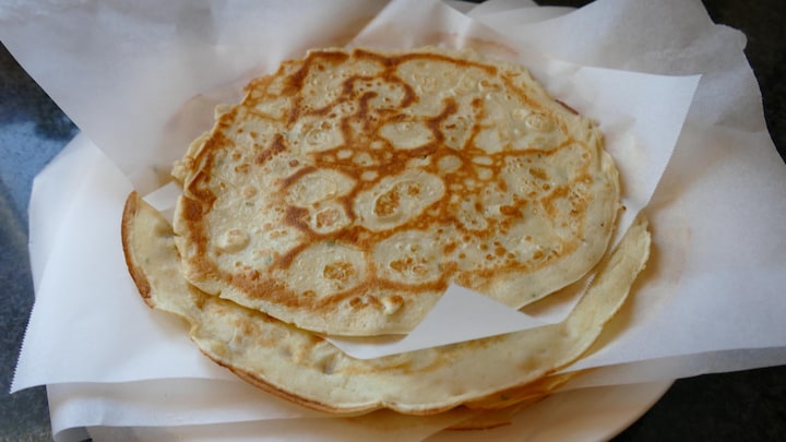 Une assiette de crêpes séparées par des papiers sulfurisés