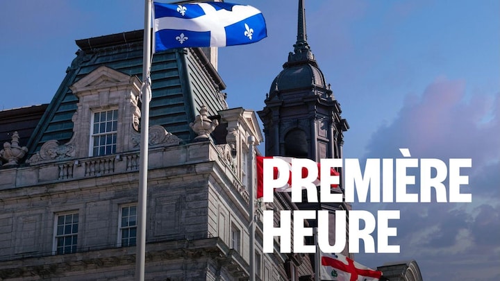 Photo du drapeau québécois qui se tient à côté du drapeau canadien devant un bâtiment officiel.