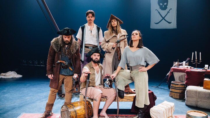 Les artistes d'un spectacle de cirque prennent la pose sur scène. Ils sont vêtus comme des pirates.