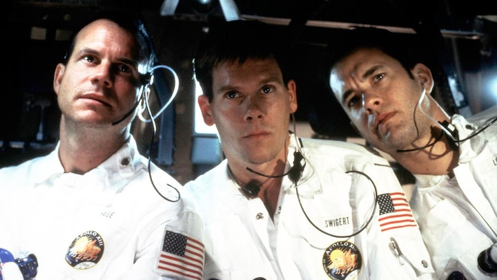 Trois hommes vêtus d'uniformes blancs dans une navette spatiale.