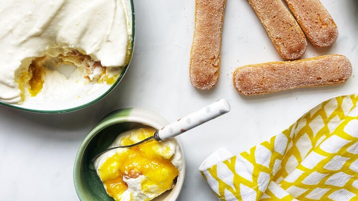 Un plat de Tiramisu, des biscuits doigt de dames, des morceaux de mangue en cubes, un bol de purée de mangue, un bol de tiramisu avec de la purée de mangue