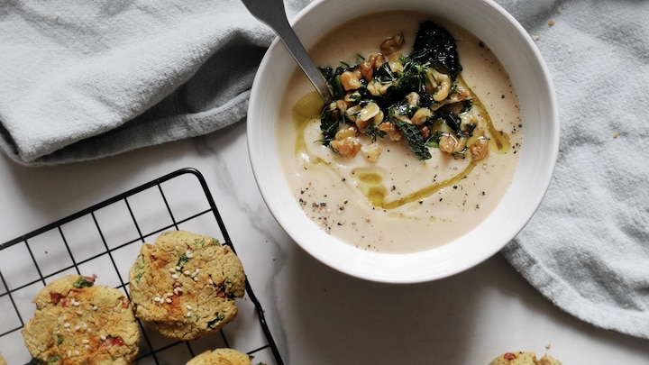 De la soupe servie dans un bol et des biscuits salés sur une plaque.