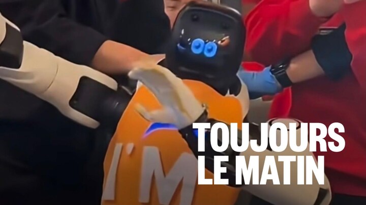 Des employés d'un restaurant tentent de retenir un robot qui bouge dans tous les sens.