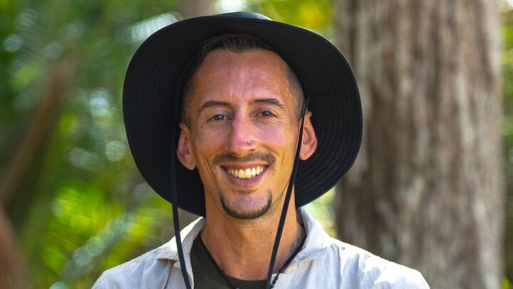 Un homme souriant avec un chapeau.