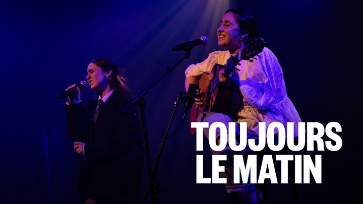Deux jeunes femmes chantent sur une scène.