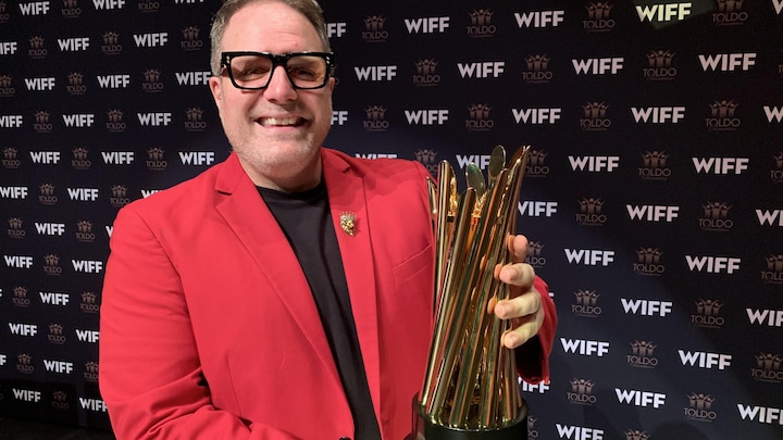 Vincent Georgie, directeur général et cook  programmeur du WIFF, tenant le nouveau trophée qui sera remis au gagnant du Prix du movie  canadien du festival