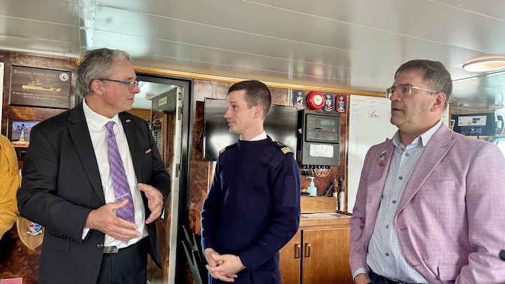 Trois hommes se tenant dans une salle du Fulmar.