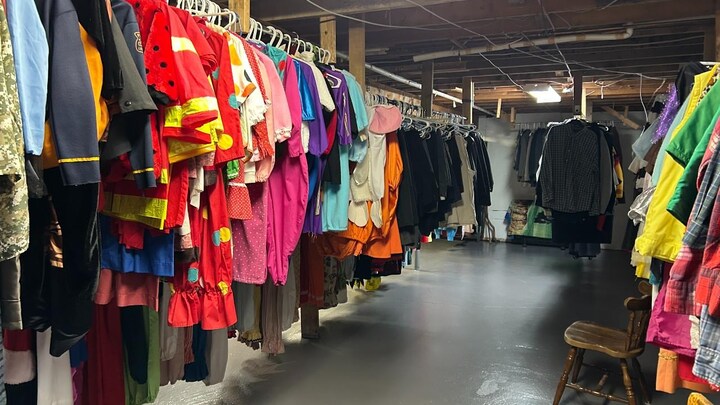 Plusieurs costumes accrochés dans un sous-sol.