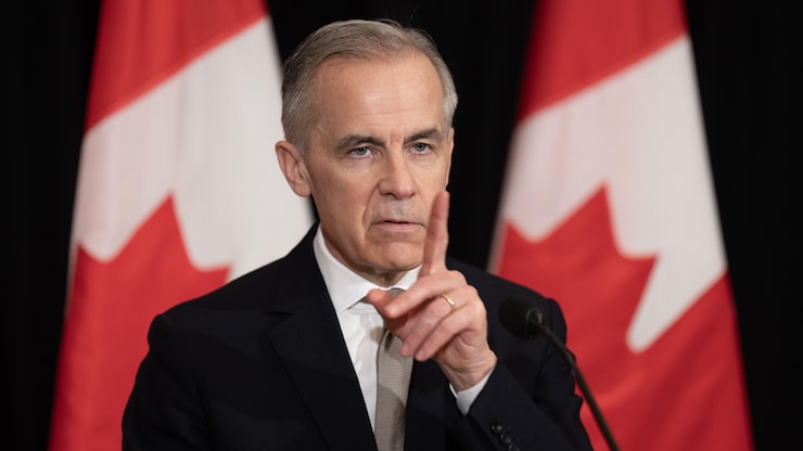 Le premier ministre du Canada, Mark Carney, lève un doigt. 