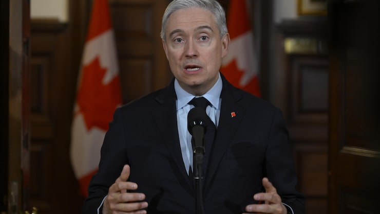 وزير المالية الفدرالي فرانسوا فيليب شامبان متحدثاً أمام الصحفيين في مبنى البرلمان في أوتاوا.
