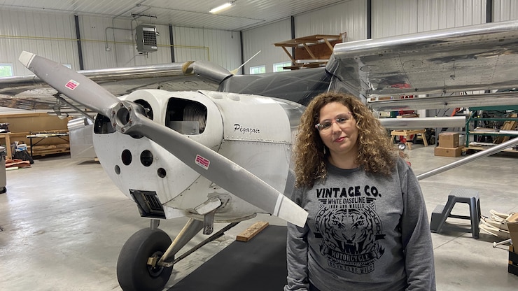 امرأة أمام طائرة.