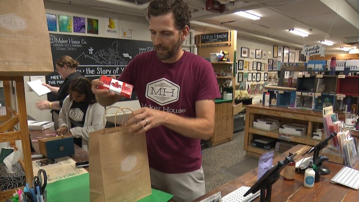 Gareth Davies putting items in a shopping bag.