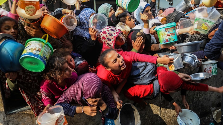 أطفال فلسطينيون محتشدون أثناء توزيع مواد غذائية في مدينة رفح في جنوب قطاع غزة خلال الحرب الأخيرة.