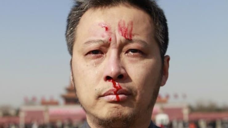 华涌在北京天安门广场用自己的血在额头上写下了 “6-4”。