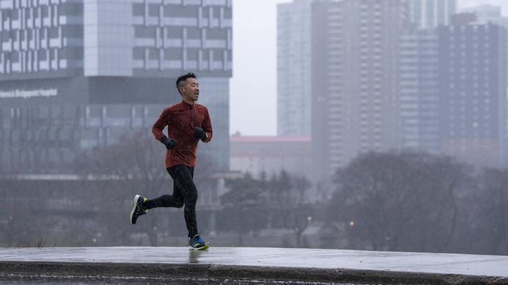 一名多倫多人在霧中冒雨奔跑。