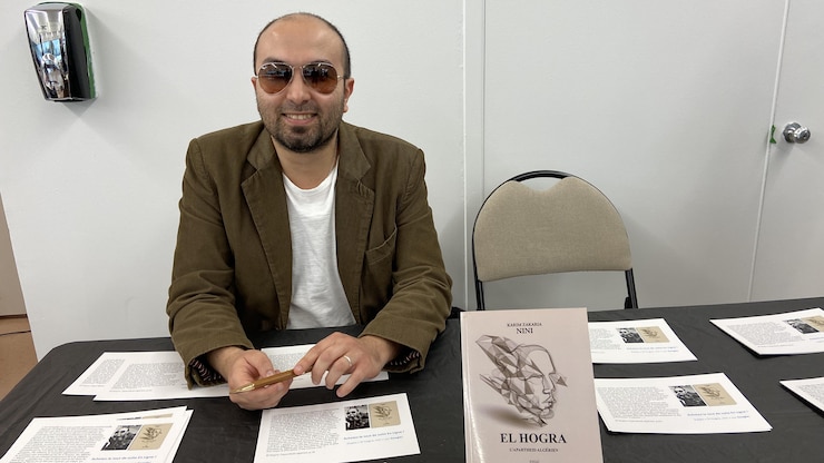 رجل جالس أمام طاولة عليها كتاب.