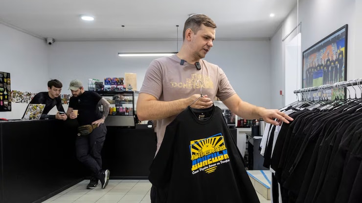 利森科（Maksym Lysenko）在服装店内展示一件T恤。