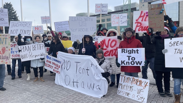 Protesters opposed to a plan to open temporary newcomer centres for asylum seekers rally outside Ottawa City Hall on Dec. 15. 