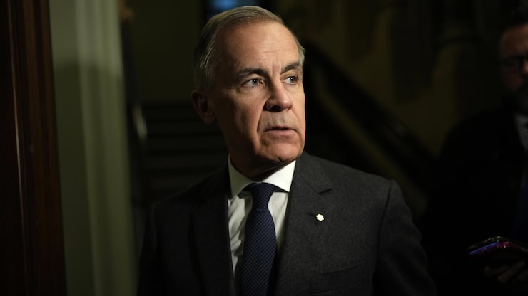 Le premier ministre Mark Carney, l'air sérieux dans un corridor du parlement.