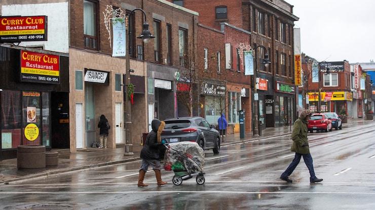 الناس يعبرون الشارع في وسط مدينة أوشاوا.