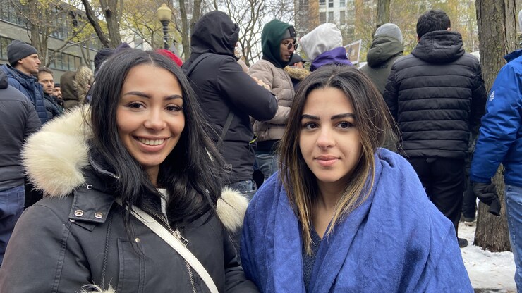 امرأتان وخلفهما مجموعة من الأشخاص.