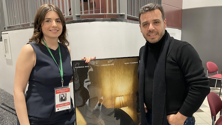 امرأة ورجل أمام ملصق.