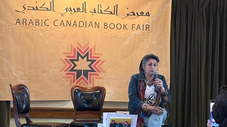 امرأة جالسة على كرسي تحمل ميكروفونا.