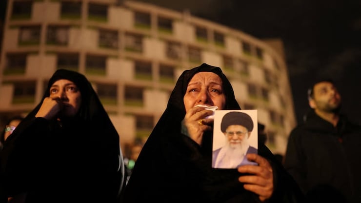 A woman holds on to a picture of Iran's Supreme Leader Ayatollah Ali Khamenei at the Vali-Asr Square, after he was killed in Israeli and U.S. strikes on Saturday, in Tehran, Iran, on Sunday. 