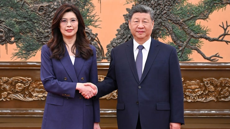Un homme et une femme en costume bleu se serrent la main.