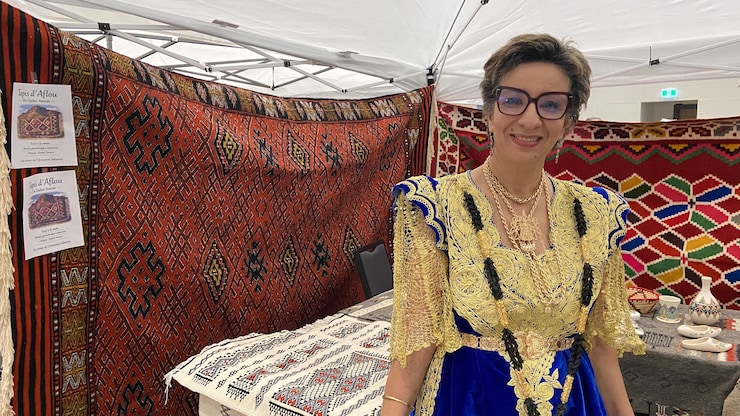 امرأة تقف وخلفها سجاد