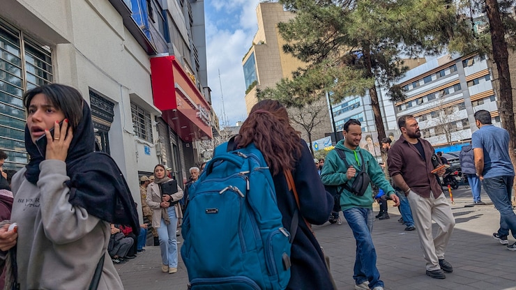 Des Iraniens courent se mettre à l'abri à Téhéran, en Iran, le 28 février 2026, alors que des explosions se font entendre après une frappe signalée et qu'Israël annonce avoir lancé une frappe contre l'Iran.