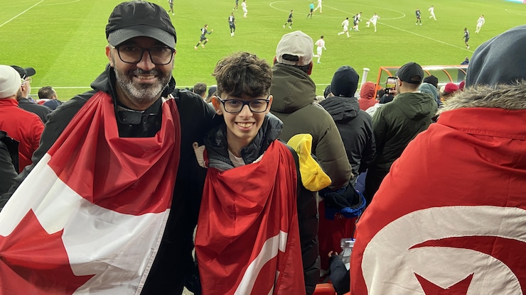 Un homme et un enfant arborant des drapeaux.
